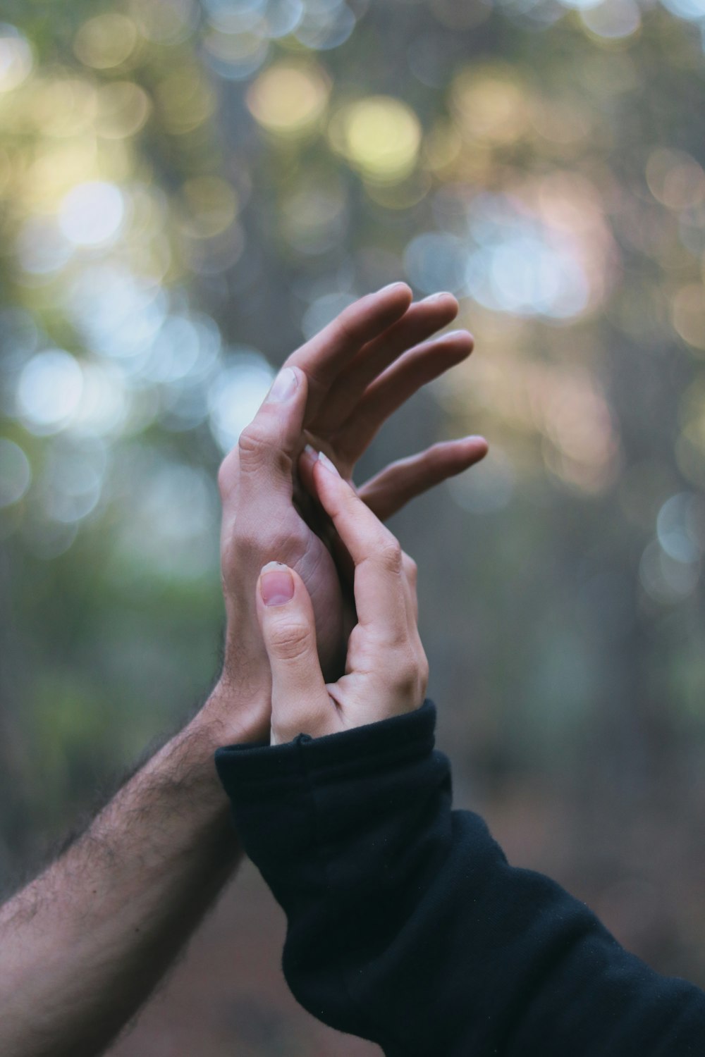 a couple of people reaching their hands together