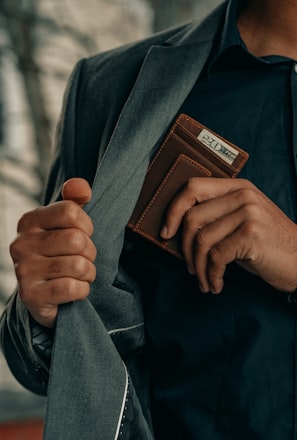 a man holding a wallet and a watch