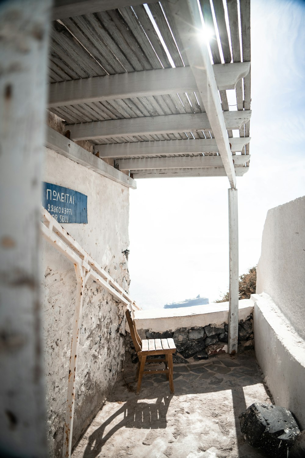 a wooden chair sitting under a white roof