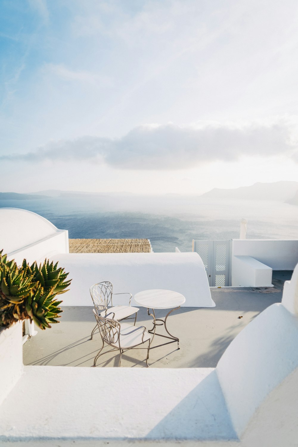 a patio with a table and chairs overlooking the ocean