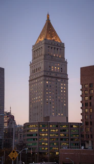 A nighttime exterior shot of a corporate building illuminated with subtle gold lighting, guarded by Prime Pirates personnel.