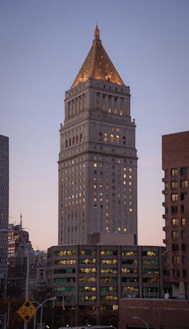 A nighttime exterior shot of a corporate building illuminated with subtle gold lighting, guarded by Prime Pirates personnel.