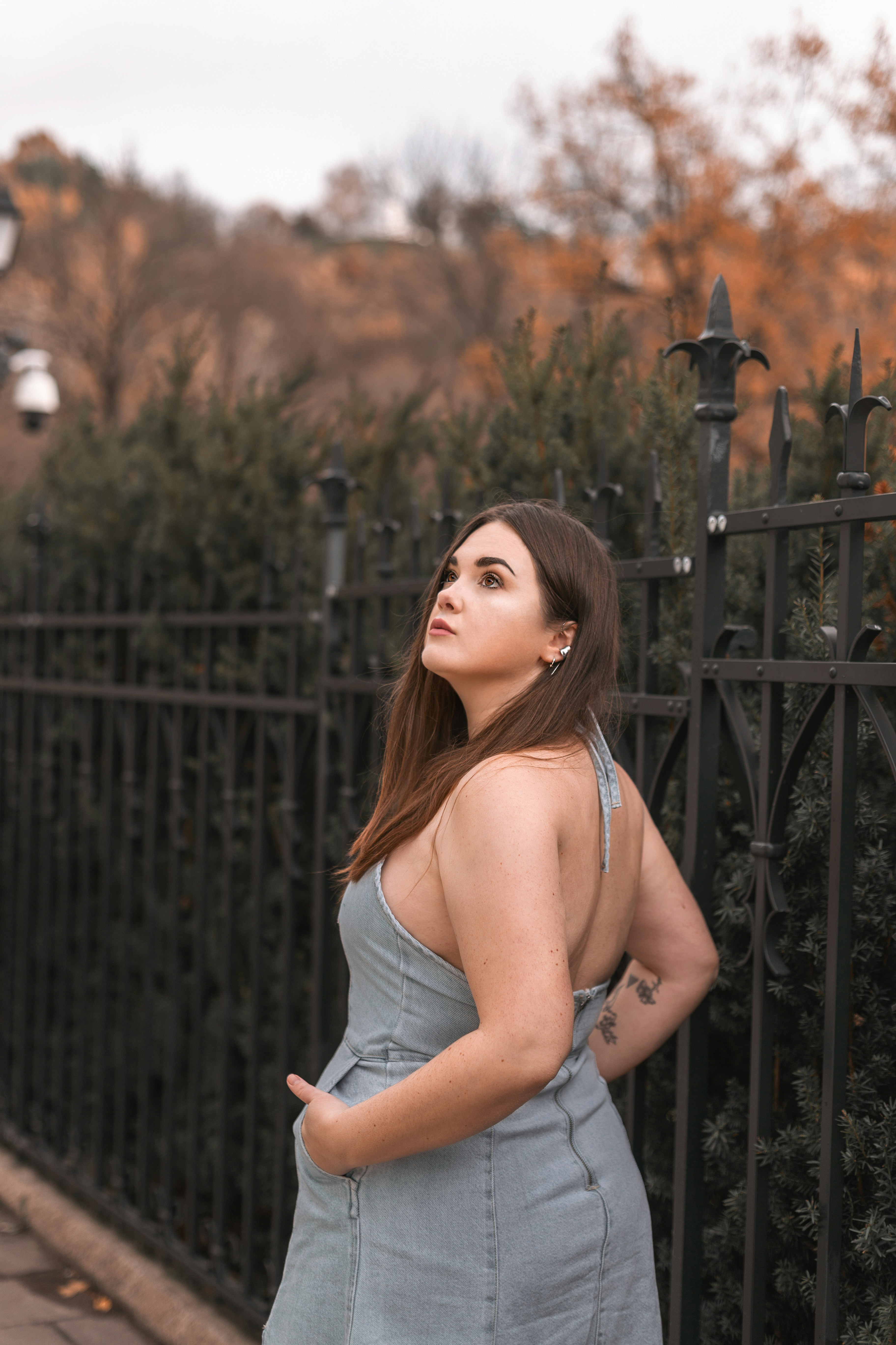 a woman standing in front of a fence