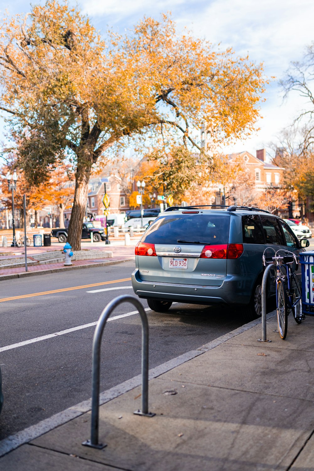 a car parked on the side of a street next to a bike rack