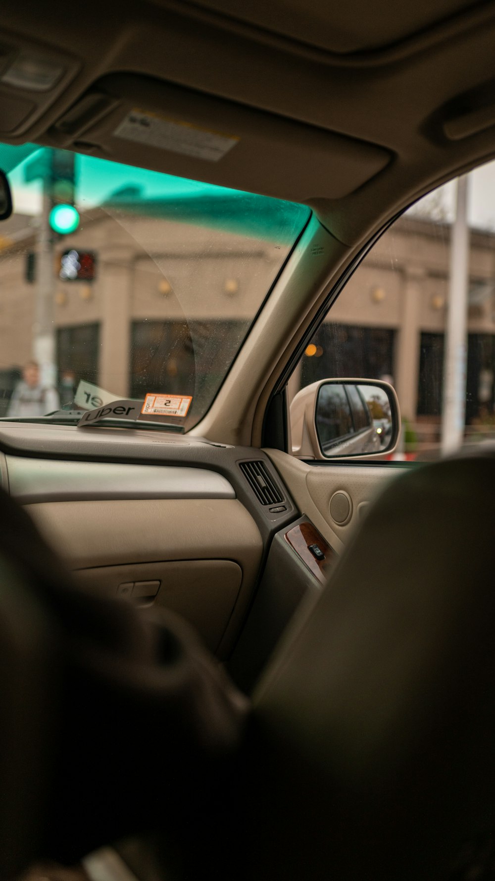 the interior of a car with a green traffic light in the background