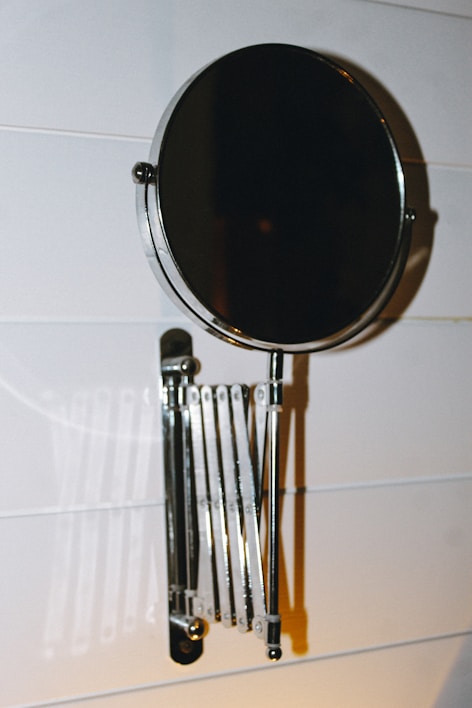 A stylish wall mirror with a modern stand.
