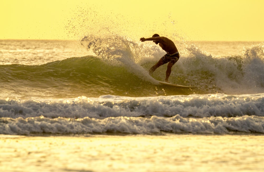 a man riding a wave on top of a surfboard