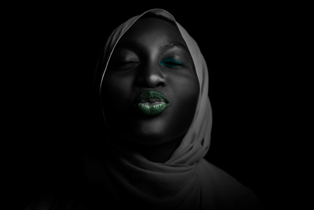 Una mujer con lápiz labial verde y un pañuelo en la cabeza