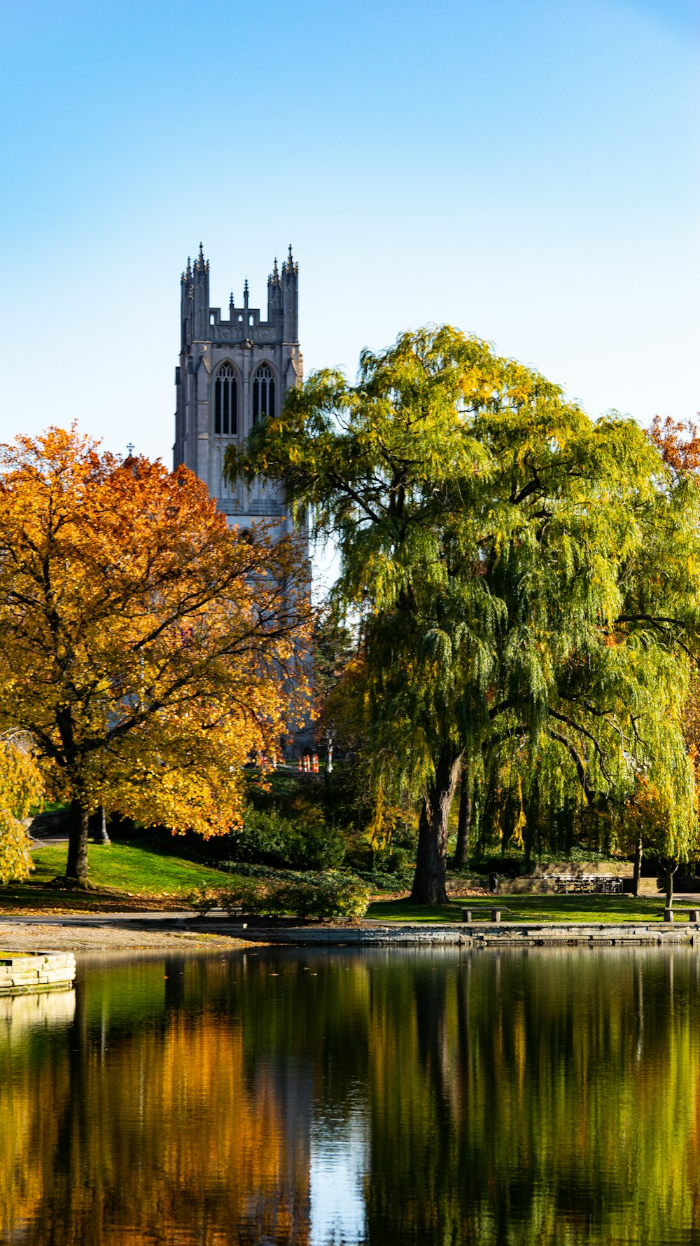 a large cathedral towering over a lake surrounded by trees