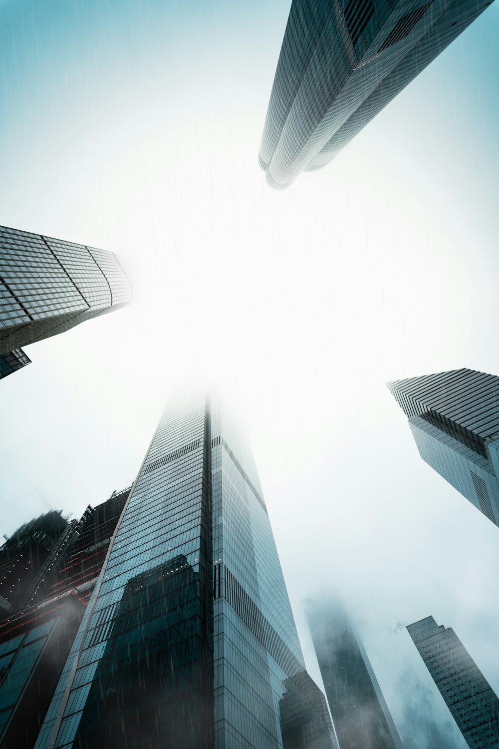 a group of tall buildings in a foggy sky