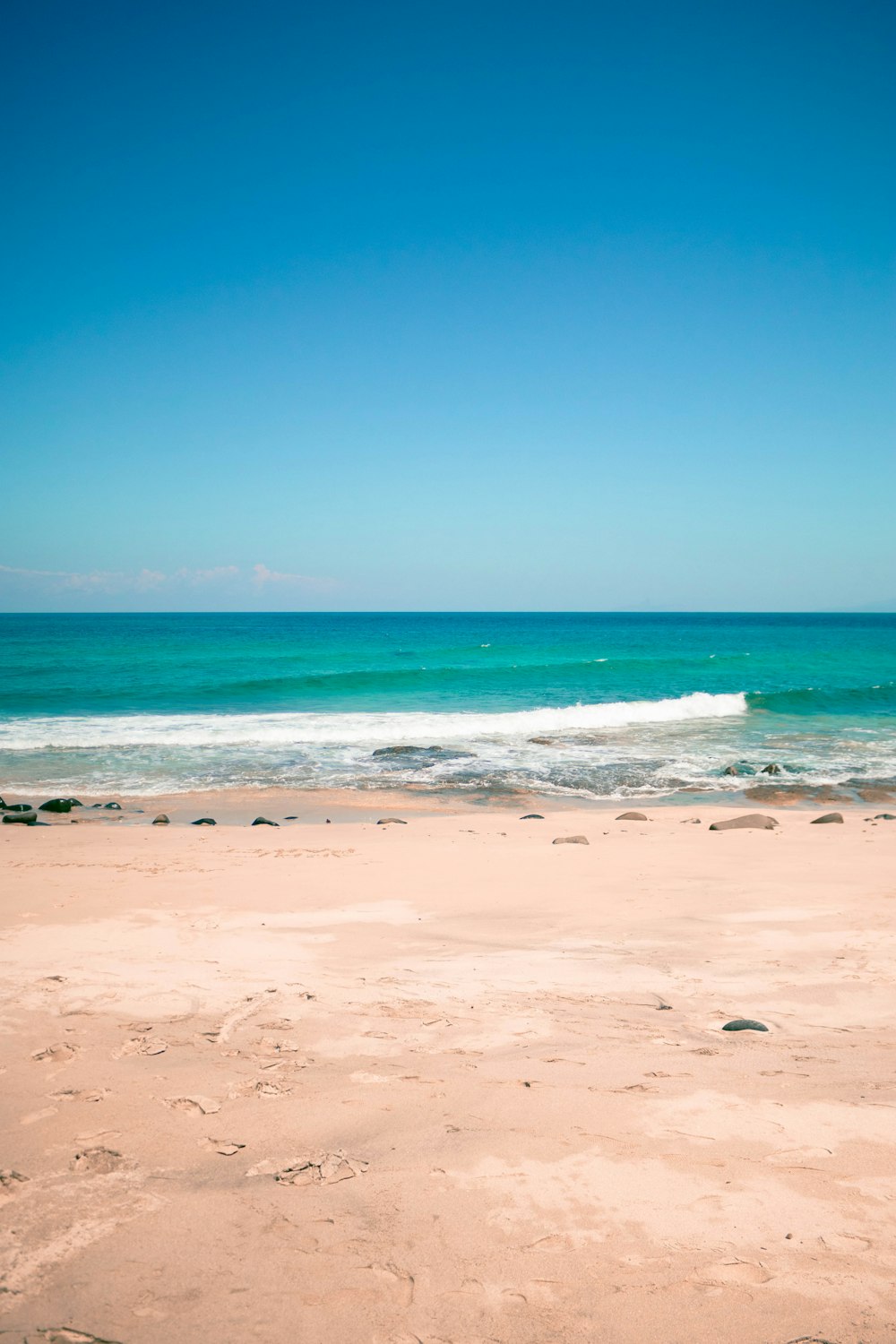 a surfboard sitting on top of a sandy beach