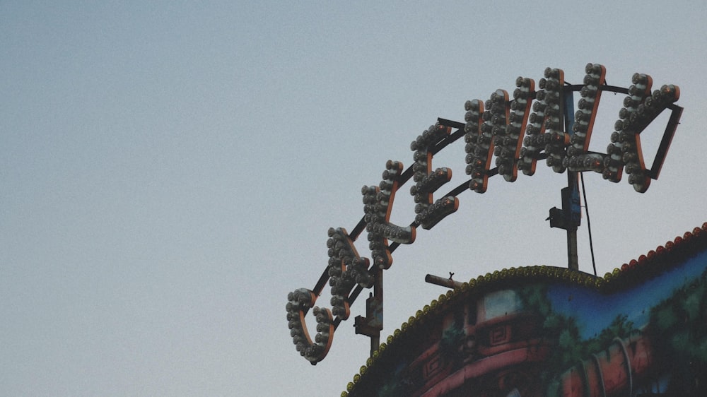 a close up of a neon sign with a sky background