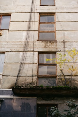Close-up of a technician inspecting cracks on an old building facade.