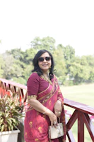 a woman in a red sari standing on a balcony