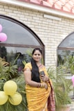 a woman in a yellow sari holding a cell phone