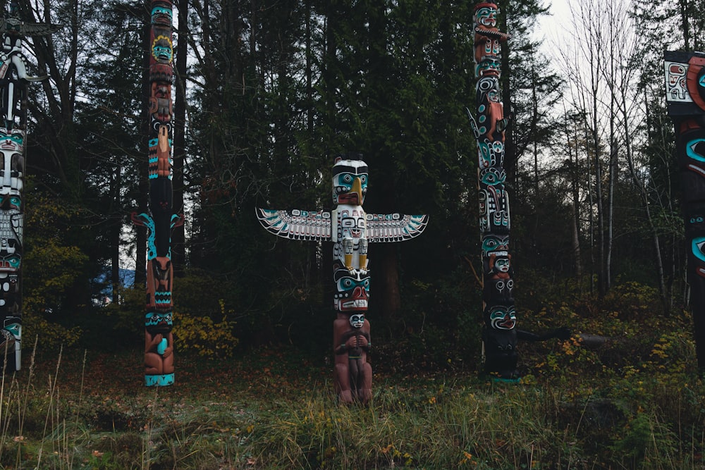 a group of totem poles standing in a forest