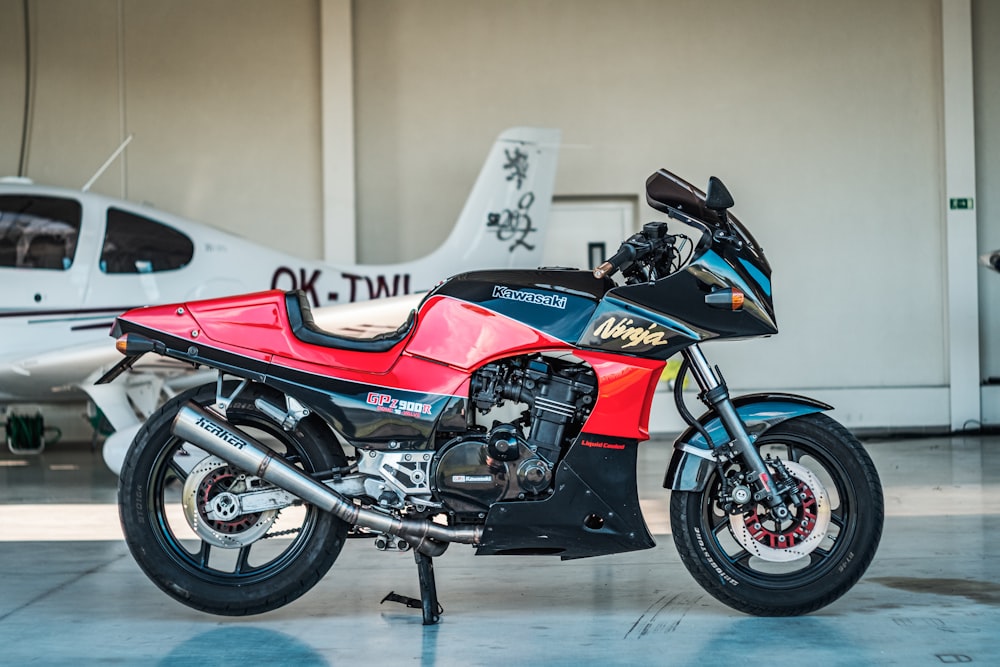 a red and black motorcycle parked in a garage