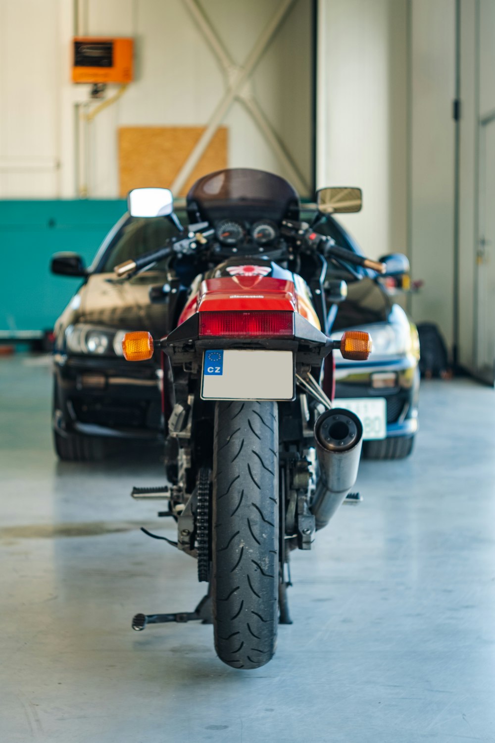 a motorcycle parked in a garage next to a car