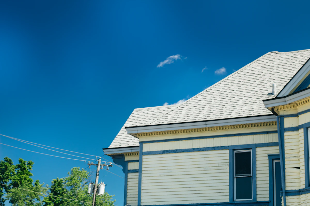Clean shingle roofline against a bright blue sky