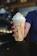 Close-up of a caramel float topped with whipped cream and a drizzle of caramel sauce.
