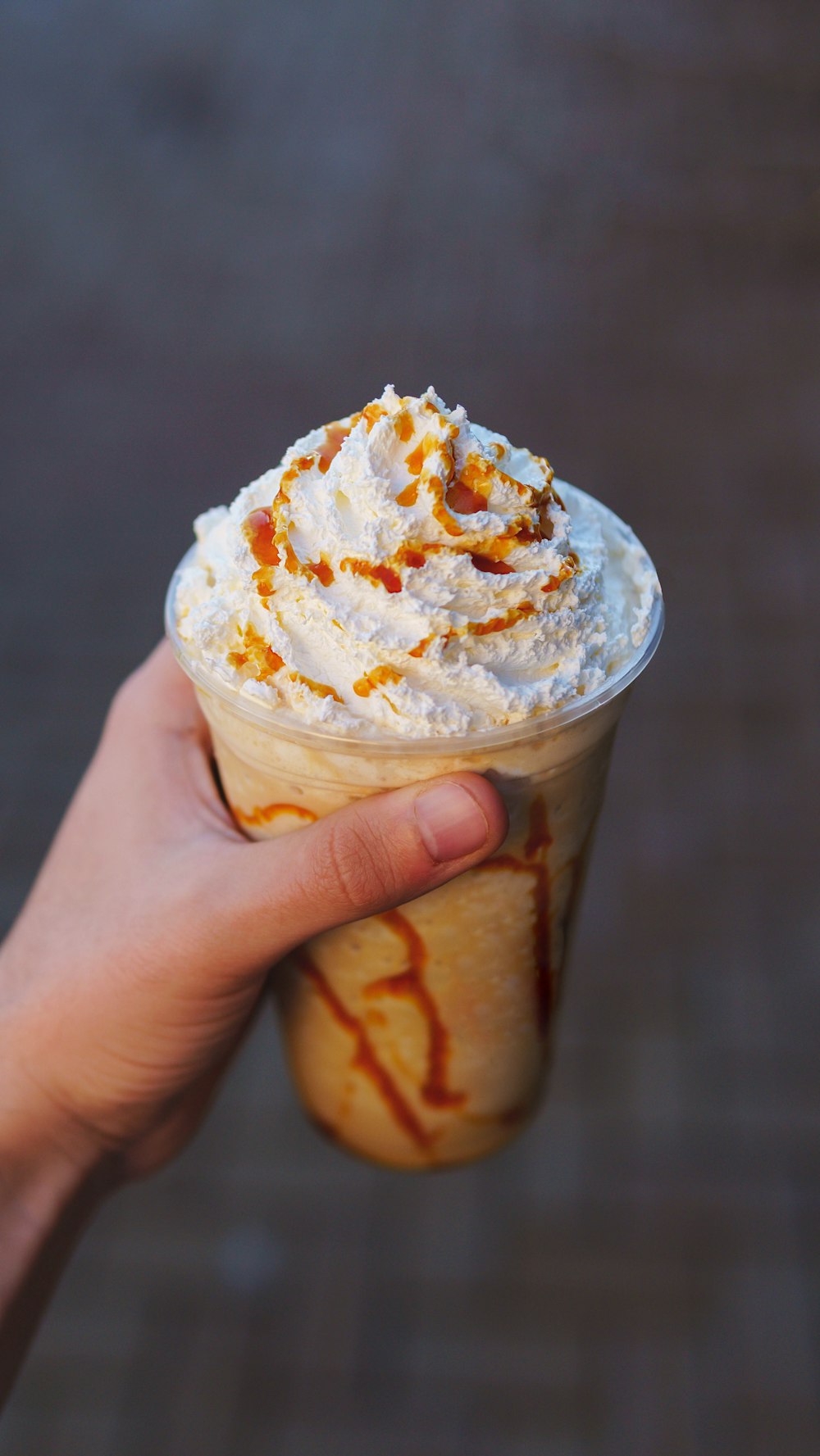 a hand holding a cup of ice cream