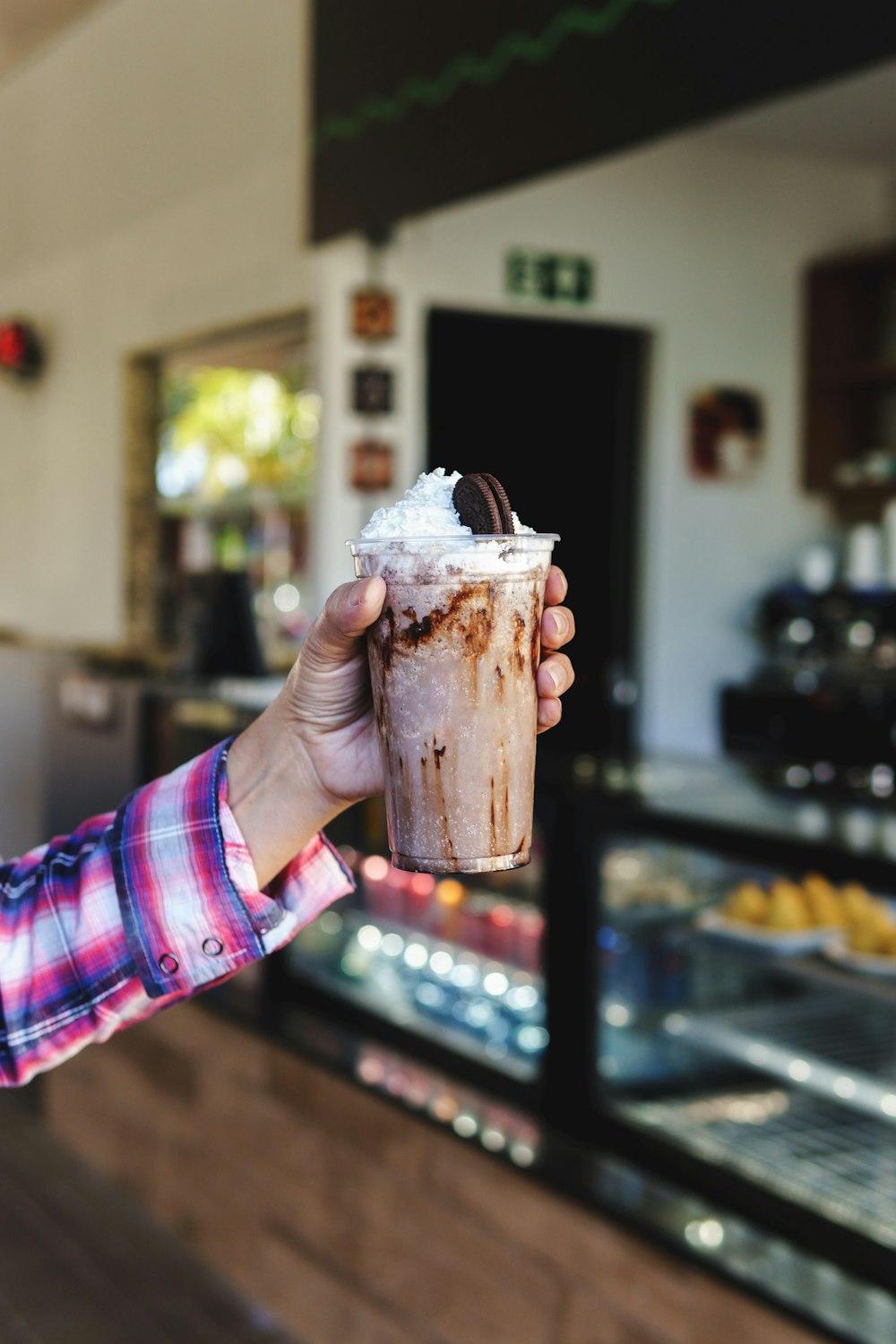 a person holding up a drink in a store