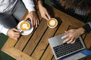 a couple of people sitting at a table with laptops