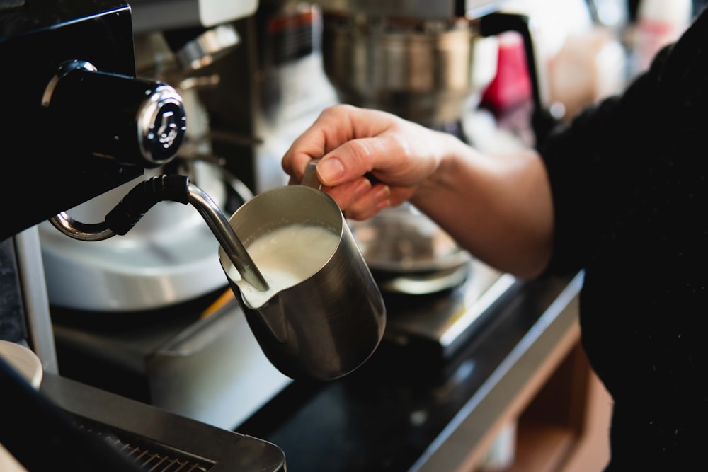 a person is pouring a cup of coffee