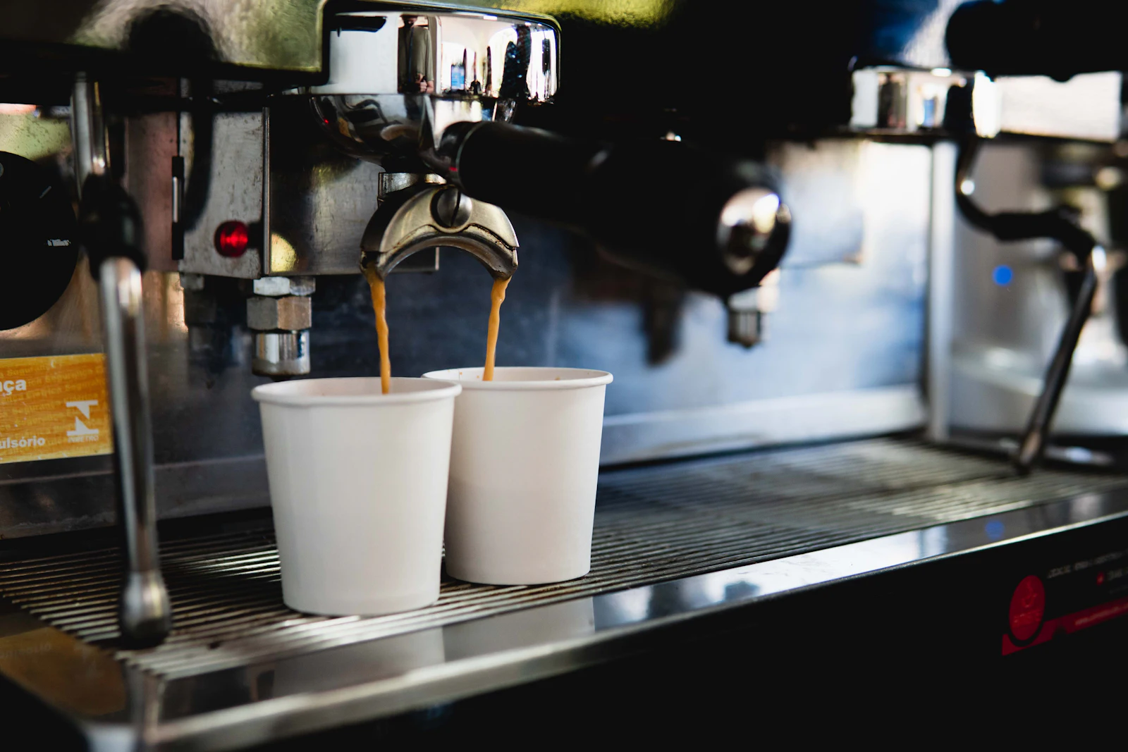 Coffee brewing into two cups beneath an espresso machine