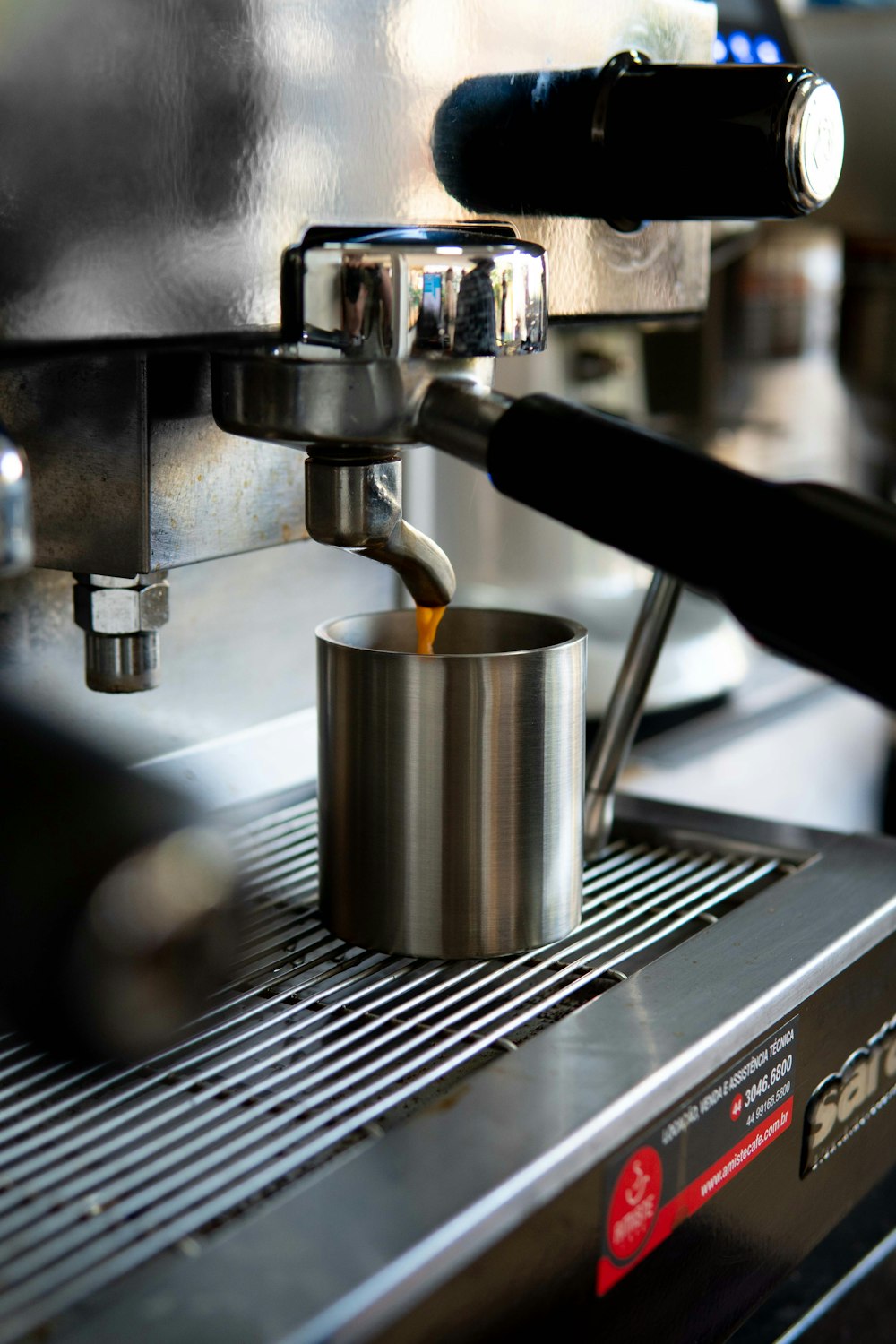 a cup of coffee being poured into a coffee machine