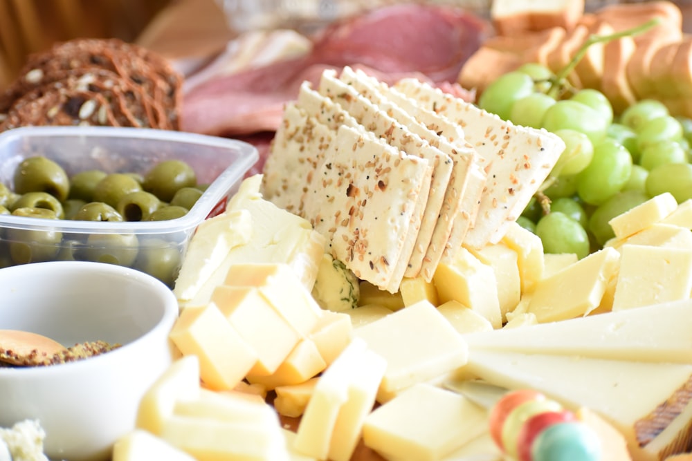 a platter of cheese, olives, and crackers