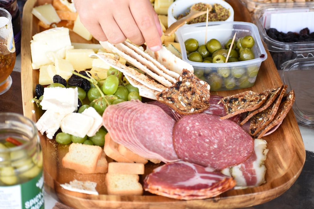a platter of meats, cheeses, and olives