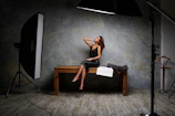 a woman sitting on a bench in front of a camera