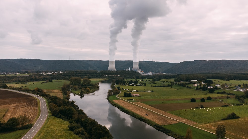 a smokestack emits from a factory near a river