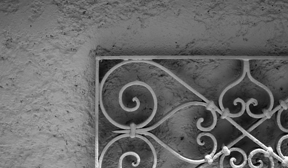 a black and white photo of a decorative iron grate