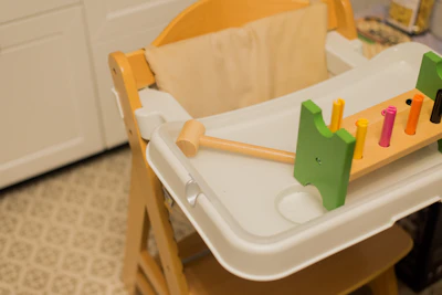 a baby's high chair with a wooden handle