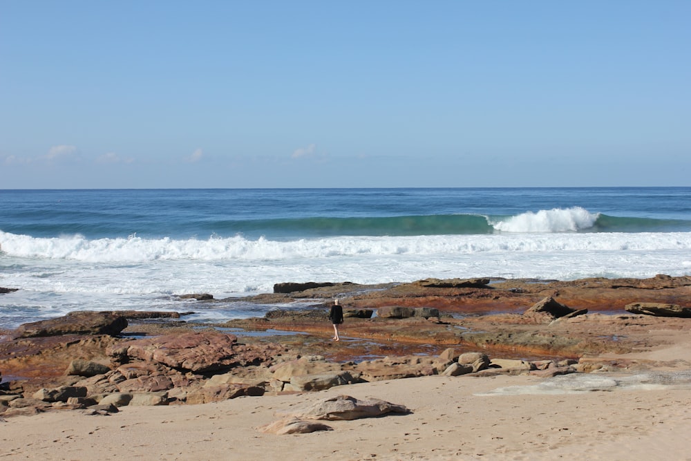 a person standing on a beach with a surfboard