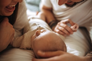 a man and woman holding a baby in their arms