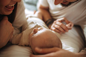 a man and woman holding a baby in their arms