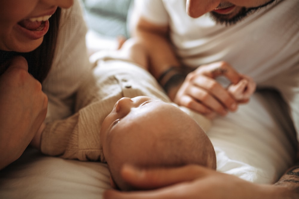 a man and woman holding a baby in their arms