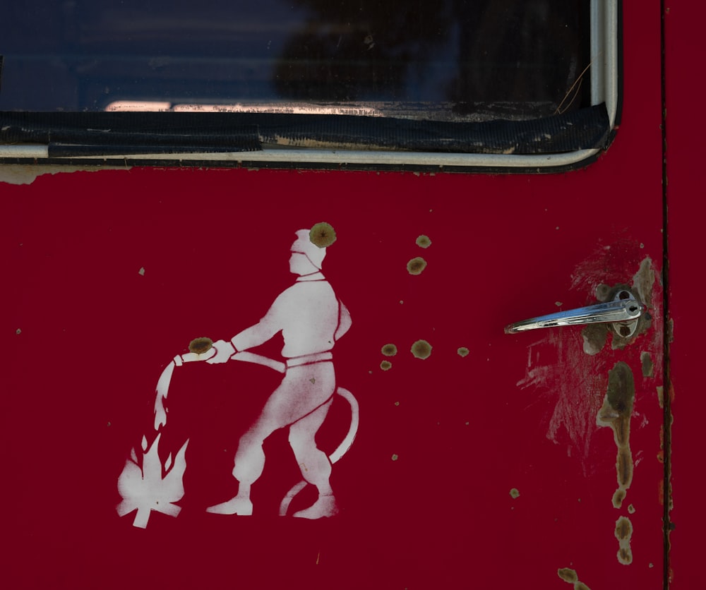 a red door with a sticker of a man holding a fire extinguis