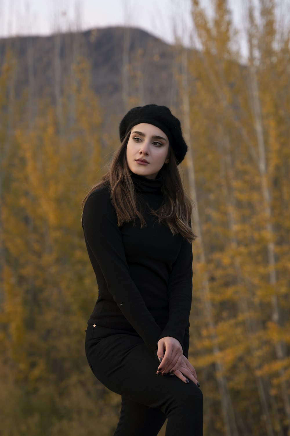 a woman in a black outfit and a black hat
