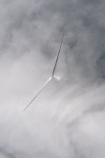 a wind turbine flying through a cloudy sky