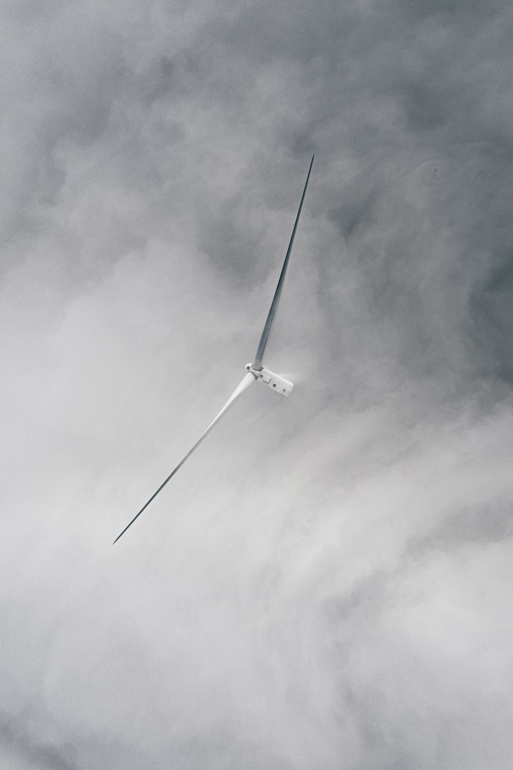 a wind turbine flying through a cloudy sky