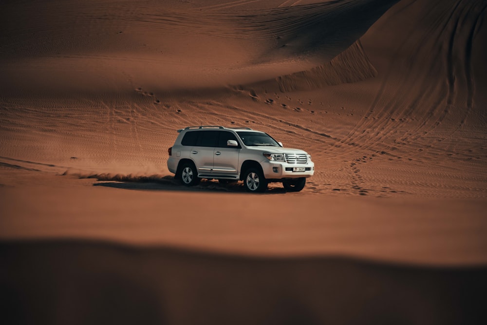 a suv driving through the desert in the desert