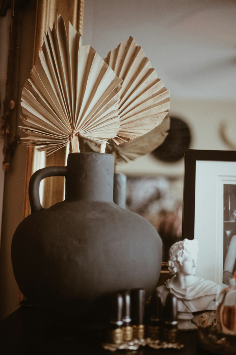 a vase with a fan on top of a table