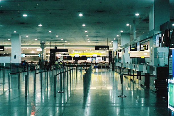 A friendly customer service agent assisting a traveler with a smile at an airport counter.