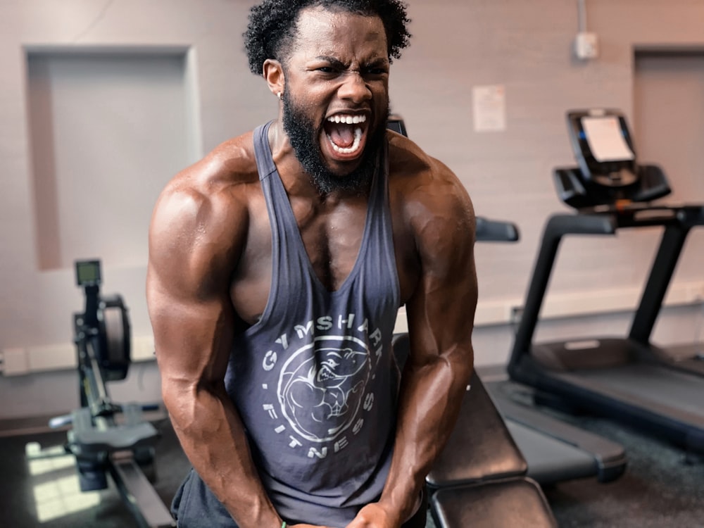 a man with a beard and no shirt on in a gym