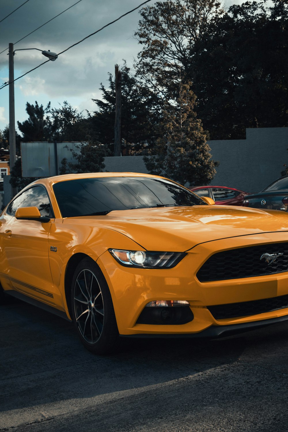 a yellow mustang car parked in a parking lot