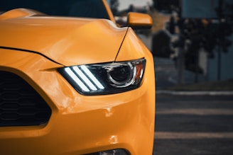a close up of the front of a yellow sports car